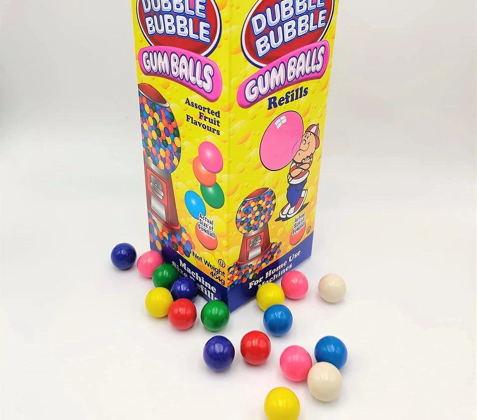 A Dubble Bubble gumball refill carton with loose gumballs scattered in front of it